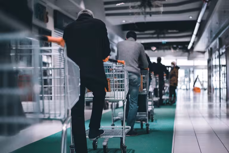 Modern crisis - people in line with shopping carts representing the daily grind